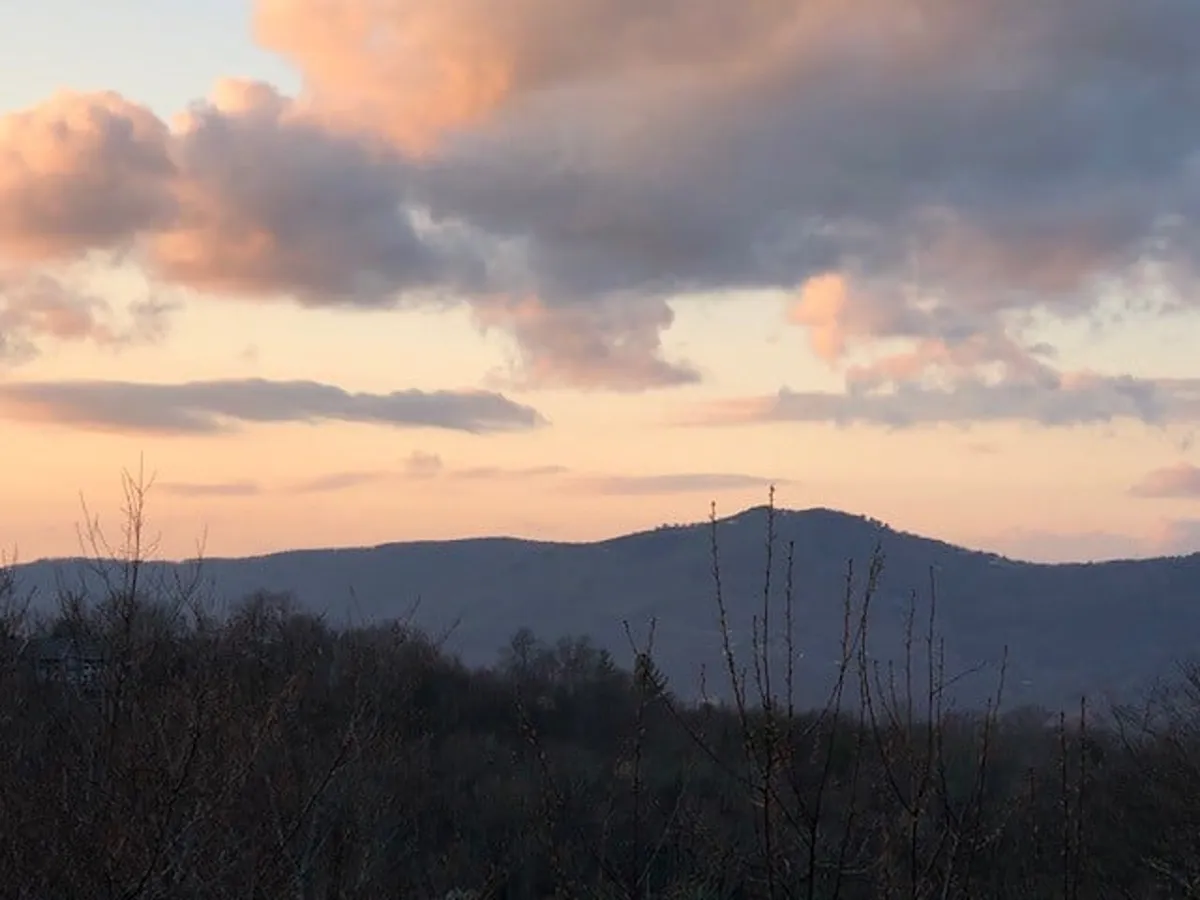 A sweeping view of the mountains and sky, with the suggestion of gathering spots for enjoying sunsets, stargazing, and sharing stories around a fire. The tranquil atmosphere sets the stage for memorable evenings spent outdoors.